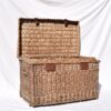 A FRENCH WICKER TRUNK WITH RED METAL BUCKLES